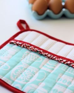 an oven mitt sitting on top of a table next to eggs