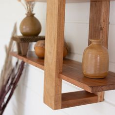 two wooden shelves with vases on them