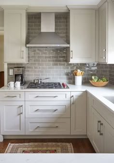 a kitchen with white cabinets and counter tops