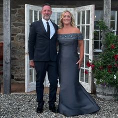 a man and woman in formal wear standing next to each other near an open door