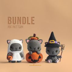 three crocheted halloween cats with pumpkins and witches hats, one holding a broom