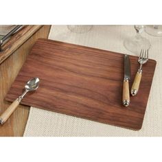 a wooden cutting board with two silverware on it next to wine glasses and utensils