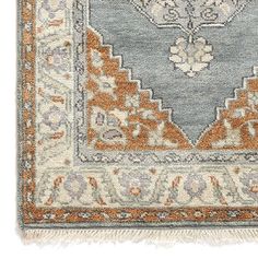 an orange and blue rug with fringes on the bottom, in front of a white background