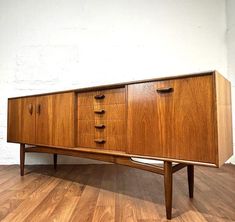 a wooden sideboard with four drawers on one end and three doors on the other