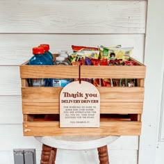 a wooden crate filled with food sitting on top of a white table next to a wall