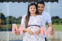 a man and woman standing next to each other in front of a glass wall with the word mom written on it