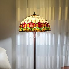 a lamp that is sitting on a table next to a chair in front of a window