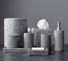 several different types of bathroom accessories on a table with gray walls and flooring in the background