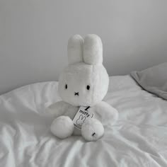 a white stuffed animal sitting on top of a bed