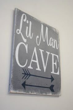 a sign that says lil man cave hanging on the wall with an arrow pointing to it