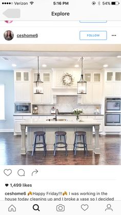 a large kitchen with white cabinets and counter tops, two stools in front of the island