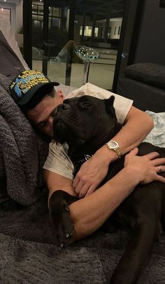 a man laying on top of a bed with a dog in his lap next to him