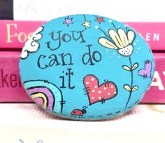 a painted rock that says you can do it with hearts and flowers on the rocks