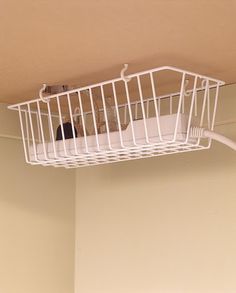 a white wire basket hanging from the ceiling