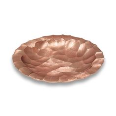 a copper plate with wavy design on the rim and bottom, sitting in front of a white background