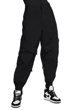 Nike Jordan Utility Nylon Pants Style#: CU2137-010 Black Plus Size: 2X Chock-a-block with pockets for stowing keys, your card case, lip balm and more, these street-savvy pants are finished with zip ankle vents for a cool ride. 27" inseam; 14" leg opening; 16" front rise; 21" back rise Zip fly with snap closure Elastic back waist Side-seam pockets; snap-flap cargo pockets; back zip pocket Reflective details enhance visibility in low light or at night Elastic hems with side zips 100% nylon Machine Crop Top Men, Halter Top Tankini, Jag Jeans, Nylon Pants, Lambskin Leather Jacket, Utility Pants, New Nike, Nike Jordan, Large Black