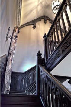 an ornate staircase with wrought iron railing and chandelier