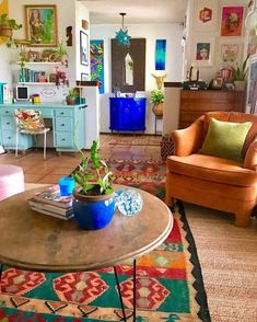 a living room filled with lots of furniture and colorful rugs on the floor next to a coffee table