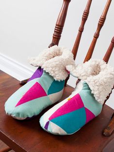 two pairs of slippers sitting on top of a wooden chair