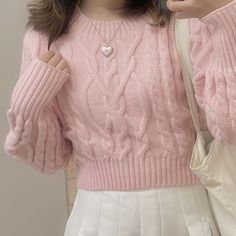 a woman is taking a selfie with her cell phone wearing a pink sweater and white pleated skirt