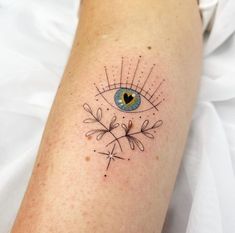 an eye tattoo on the left arm with lines and dots around it's eyes