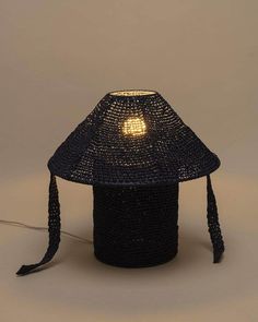 a lamp made out of woven material with a small light on top of the head