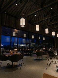 an empty restaurant with large windows at night