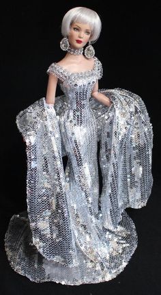 a barbie doll wearing a silver dress with sequins