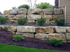 a large rock wall in front of a house