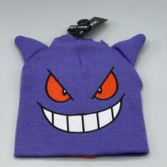 a purple beanie with an evil face and big red eyes on it's side