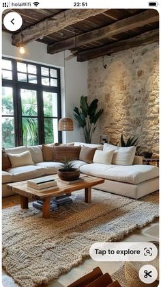 a living room filled with furniture and a stone wall behind the couch is a coffee table