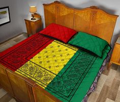 a bed with a colorful comforter on top of it in a room next to a wooden headboard