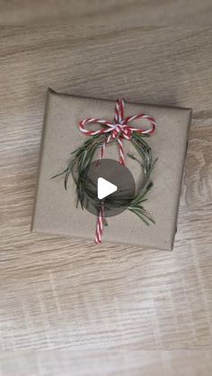 a gift wrapped in brown paper with a red and white ribbon