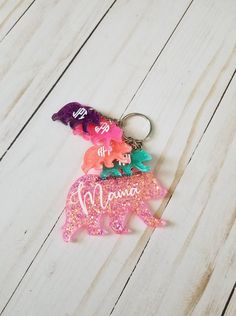 a keychain with the word mama written on it and flowers in pink, green, purple, and orange