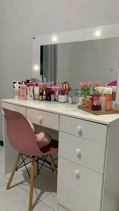 a white desk topped with lots of makeup and personal care items next to a mirror