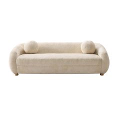 a white couch with two pillows on it's back and one pillow sitting on the top