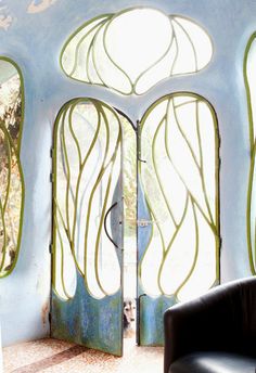 a chair sitting in front of an open door to a room with glass panels on the walls