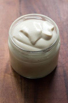 a jar filled with cream sitting on top of a wooden table