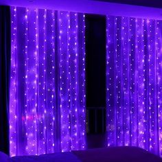 a bedroom with purple lights on the curtains