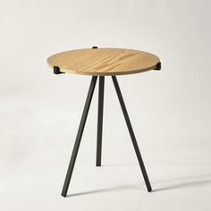 a small wooden table with black legs and a round top, on a white background