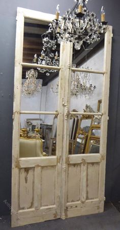 an old wooden door with chandelier hanging from it's top and bottom