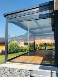 a glass enclosed patio with sliding doors on the side