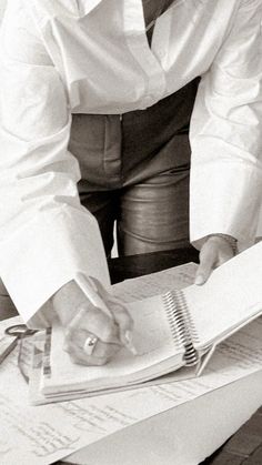 black and white photograph of a person sitting at a desk with papers in front of them