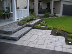 a house with steps leading to the front door and landscaping area next to it,