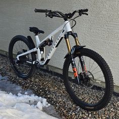 a white mountain bike parked next to a building