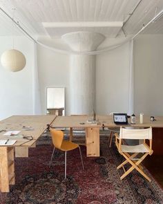 a room with a rug, table and chairs on the floor in front of it