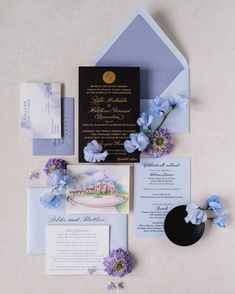 the wedding stationery is laid out with blue flowers