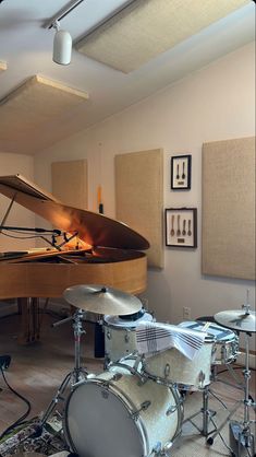 a room with a piano and drums in it