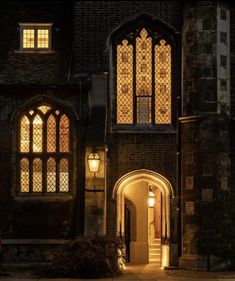 an old building lit up at night with light coming through the windows and door way