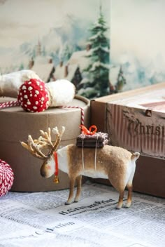 there is a small deer figurine next to a box with presents on it